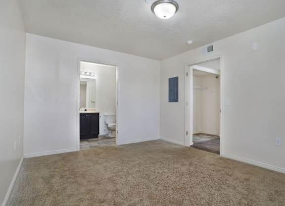 A room with a carpeted floor and a toilet in the corner.