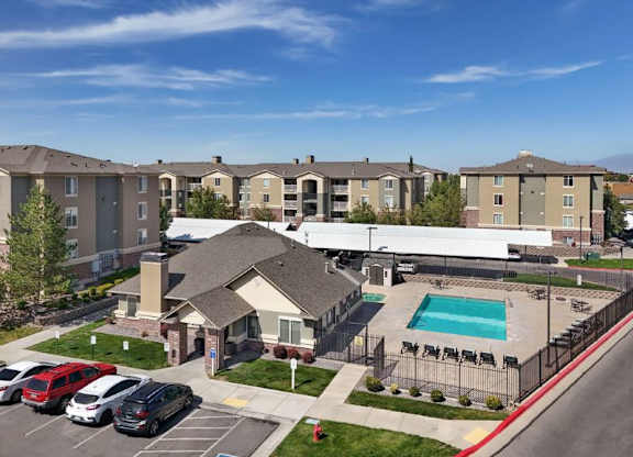 A large apartment complex with a pool and a covered walkway.