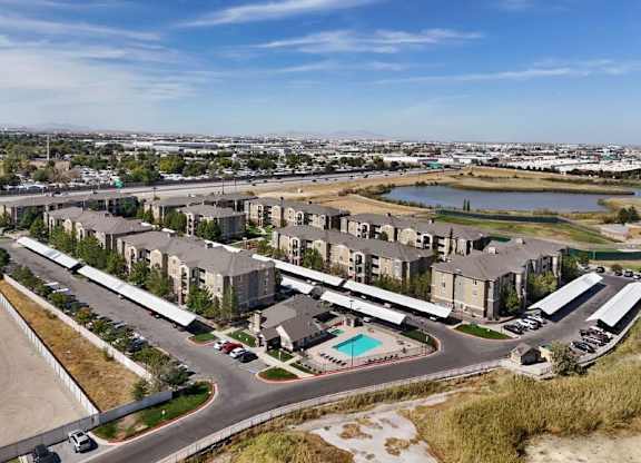 A large apartment complex with a pool and a parking lot.