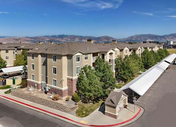 Apartment complex with a parking lot in front.