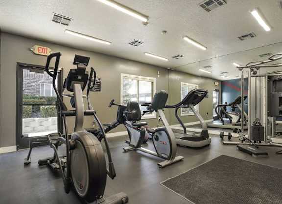 A gym with a variety of equipment including treadmills, stationary bikes, and weight machines.