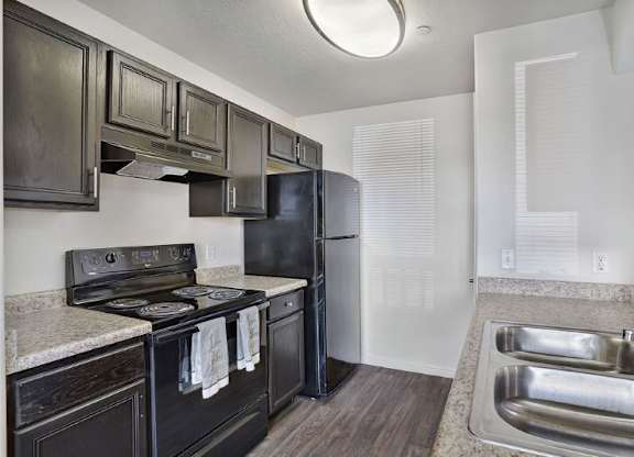 A kitchen with black appliances and wooden cabinets.