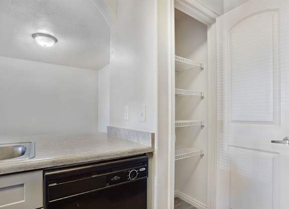 A kitchen with a black oven and white cabinets.
