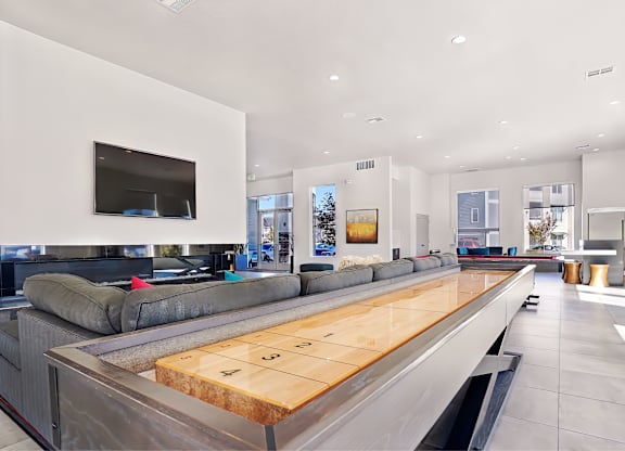 A modern living room with a long wooden table in the center.