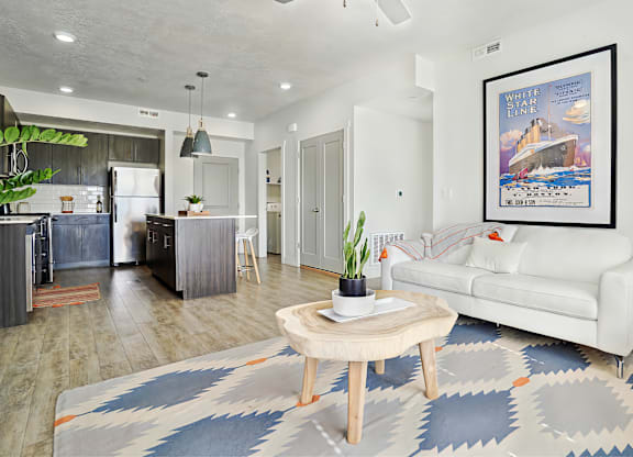 A living room with a white couch and a framed poster on the wall.