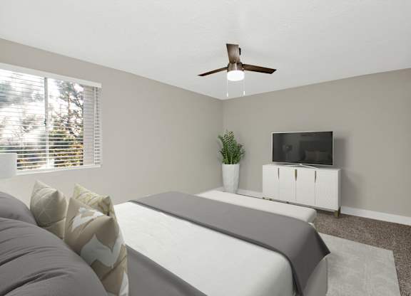 A bedroom with a bed, a television, and a plant.