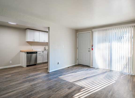 A kitchen with a dishwasher and a sink is visible through a window.