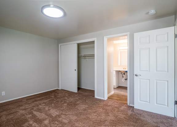 A room with a carpeted floor and a white door.