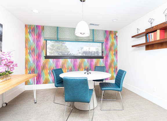 A dining room with a white table and blue chairs.