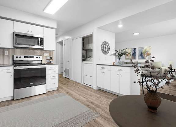A modern kitchen with white cabinets and stainless steel appliances.