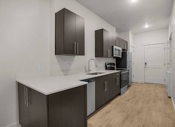 A kitchen with dark brown cabinets and a white counter.