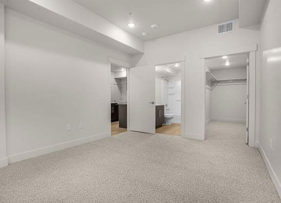 A spacious room with carpeted floor and white walls.