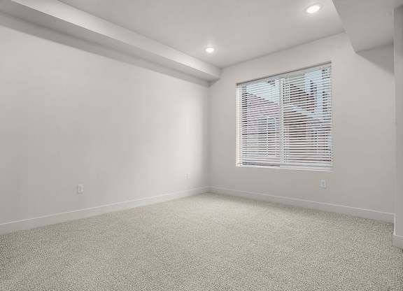 A room with a window covered by blinds.