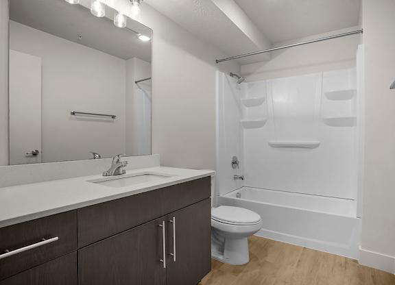 A white bathroom with a toilet, sink, and shower.
