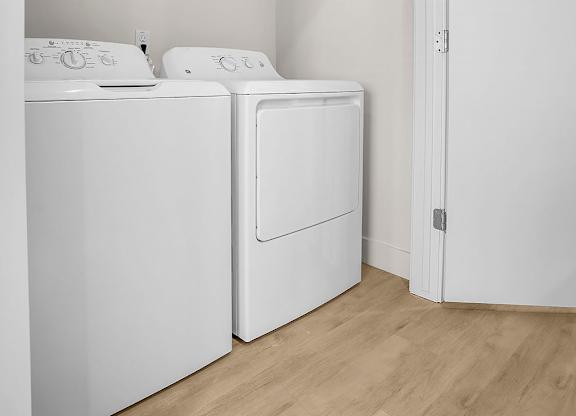 A white washing machine and dryer in a small laundry room.