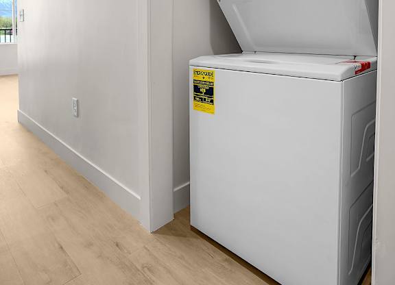 A white dishwasher is in a kitchen with a sticker on it.