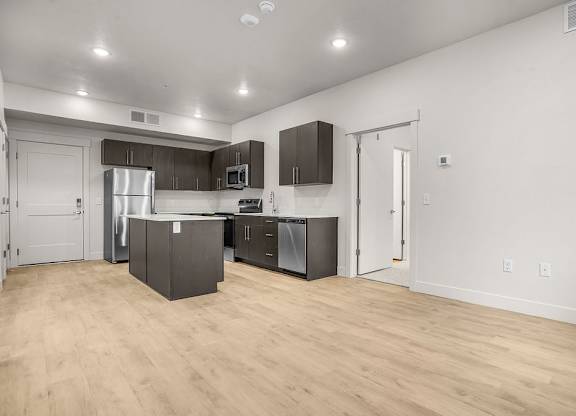 A kitchen with wooden floors and white walls.