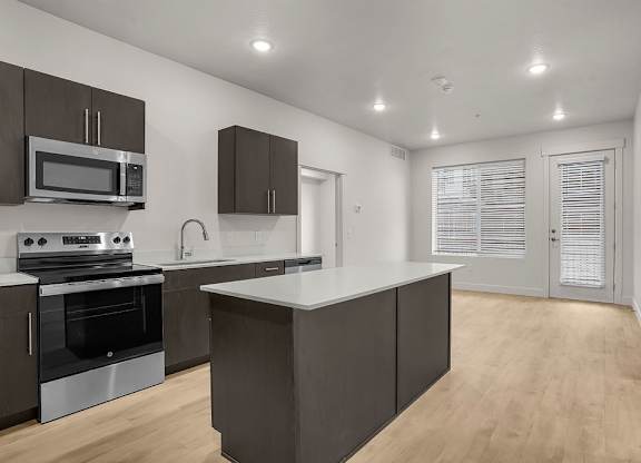 A modern kitchen with dark brown cabinets and stainless steel appliances.