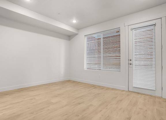 A room with wooden flooring and white walls.