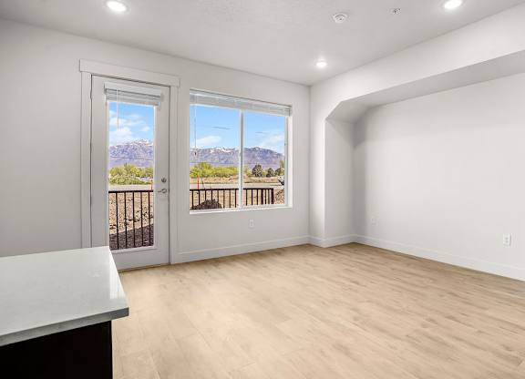 A room with a balcony overlooking a mountainous landscape.