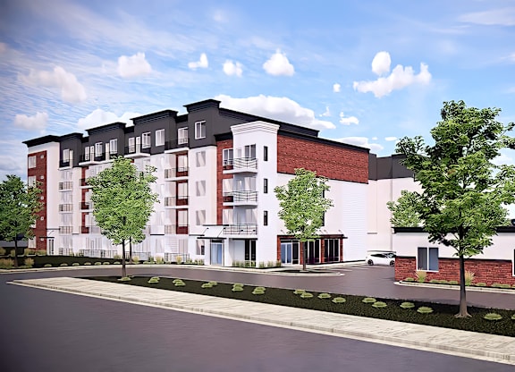 A modern apartment building with a parking lot in front.