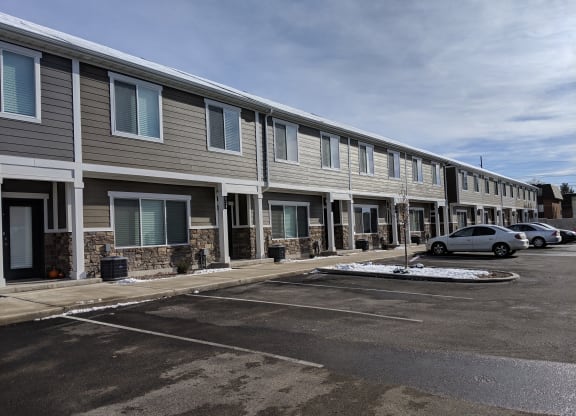 a row of apartment buildings in a parking lot