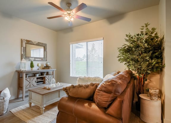 a living room with a ceiling fan and a large window