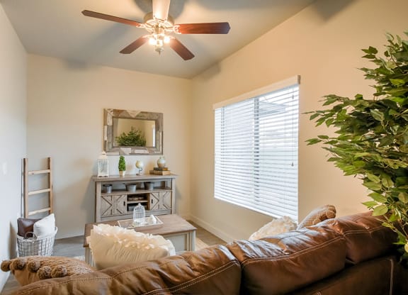 a living room with a ceiling fan and a large window
