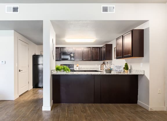 a kitchen with dark wood cabinets and a white counter top