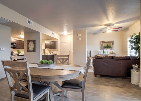 an open floor plan with a dining table and chairs and a living room with a couch and