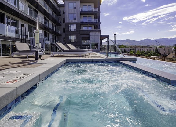 a pool with people swimming in it next to a building
