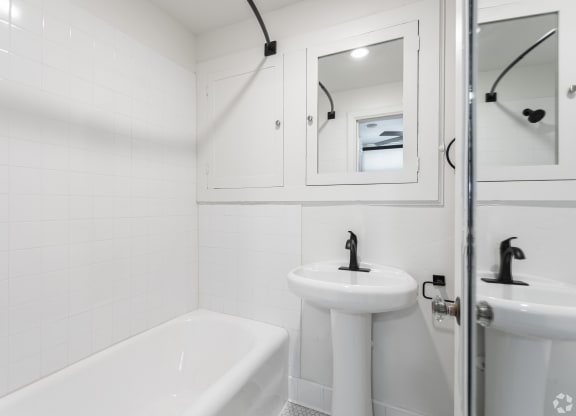a bathroom with a sink and a tub and a mirror
