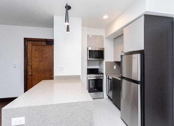 a kitchen with stainless steel appliances and a white counter top