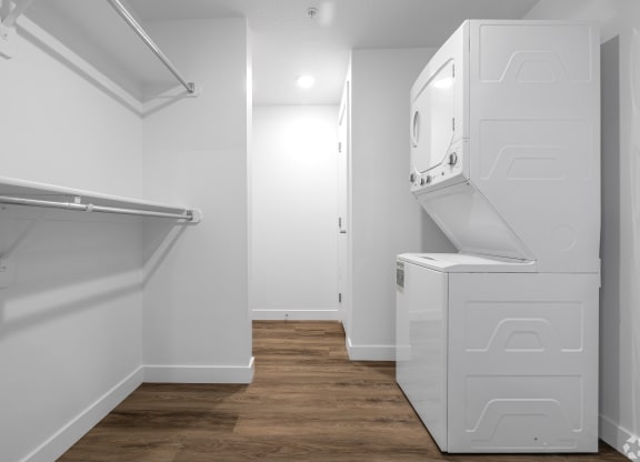 a white laundry room with a washer and dryer and a wood floor at Lotus Gallacher luxury apartments for rent in Salt Lake City, UT