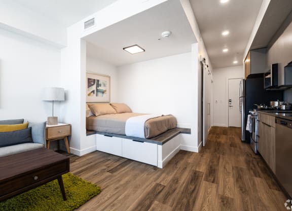 a bedroom with a bed and a couch in a small room at Lotus Gallacher luxury apartments for rent in Salt Lake City, UT