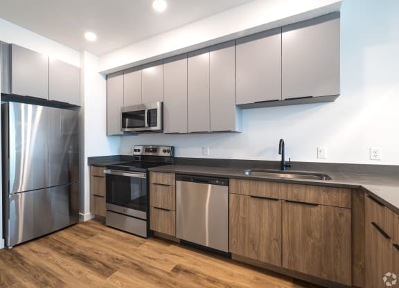 a kitchen with white cabinets and stainless steel appliances at Lotus Gallacher luxury apartments for rent in Salt Lake City, UT