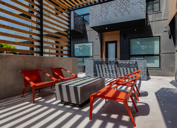 a patio with red chairs and a and a firepit at Lotus Gallacher luxury apartments for rent in Salt Lake City, UT