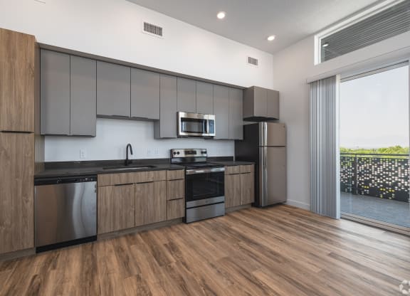 a modern kitchen with stainless steel appliances and wooden cabinets at Lotus Gallacher luxury apartments for rent in Salt Lake City, UT