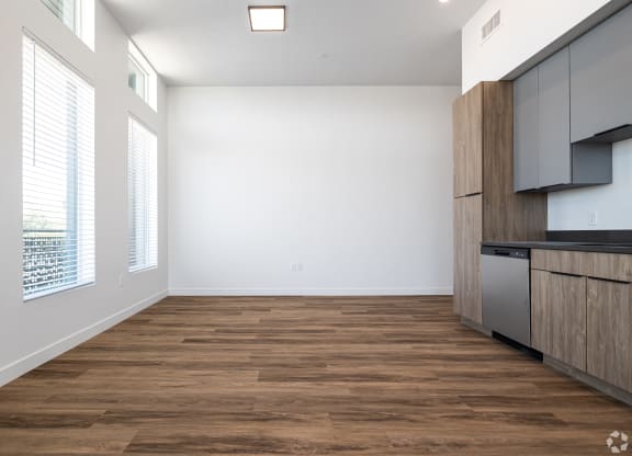 an empty living room with wood flooring and a kitchen at Lotus Gallacher luxury apartments for rent in Salt Lake City, UT