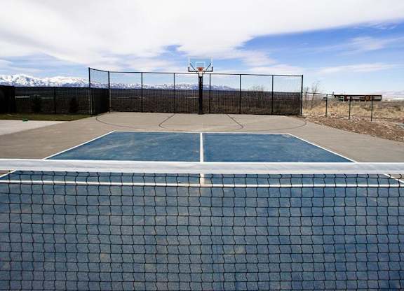 A tennis court with a net and a fence.