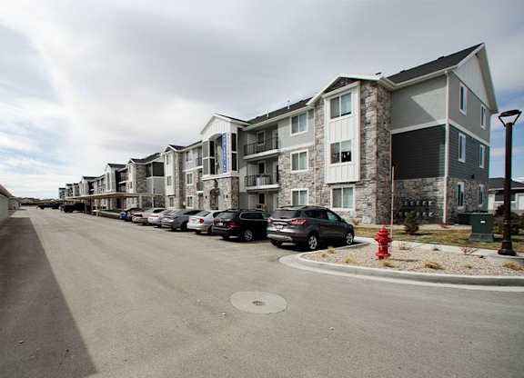 A row of houses with cars parked in front.