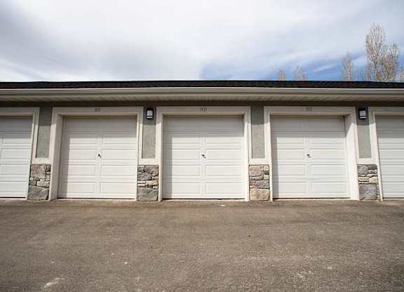A row of four white garage doors are closed.