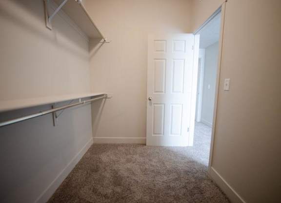A white door is in a room with a grey carpet.