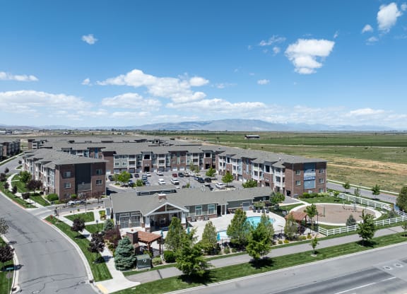an aerial view of an apartment complex with a pool and flag at Outlook Apartments for rent in Springville and Provo, UT.