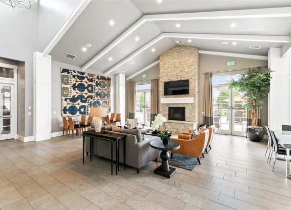 a large and modern fireplace area with vaulted ceilings and couches and chairs at Outlook Apartments for rent in Springville and Provo, UT.