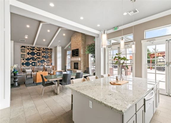 a bright and modern clubhouse with couches, chairs, and a kitchen with marble counter tops at Outlook Apartments for rent in Springville and Provo, UT.