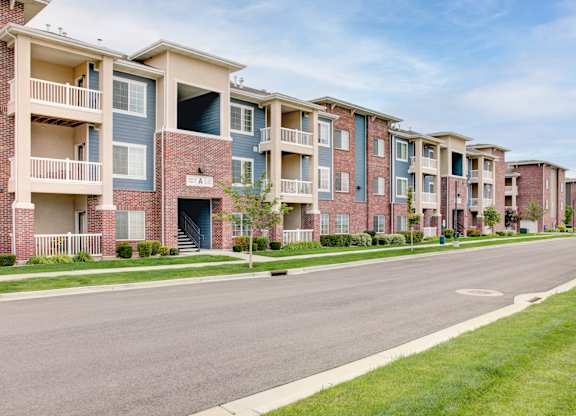Apartment buildings with balconies line a street.