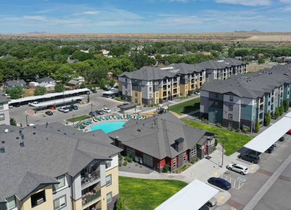 an aerial view of a large apartment complex with a pool and parking lot