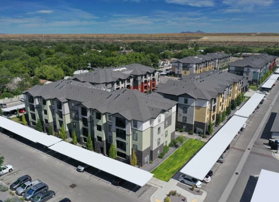 an aerial view of a row of apartment buildings with trees in the background