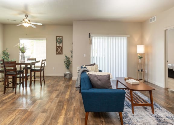 a living room and dining room with hardwood floors and a ceiling fan